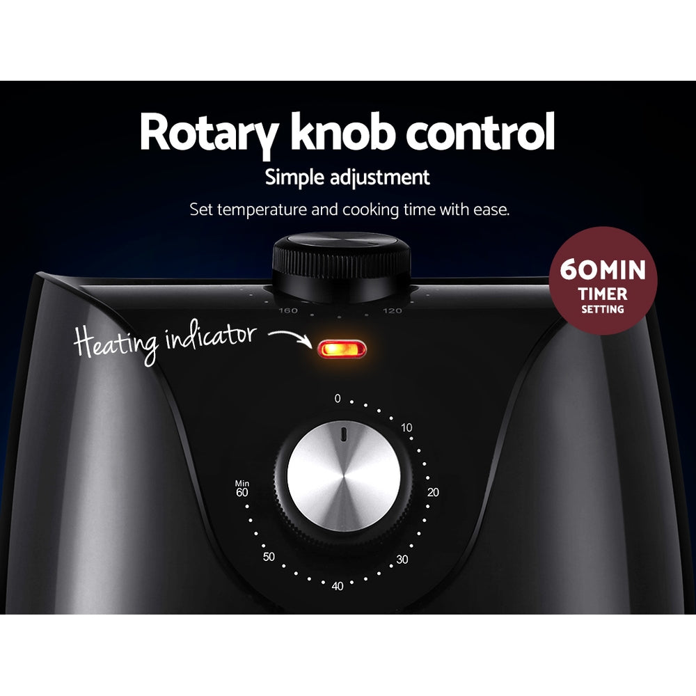 Close-up of black air fryer control panel with rotary knob, heating indicator, and timer setting.