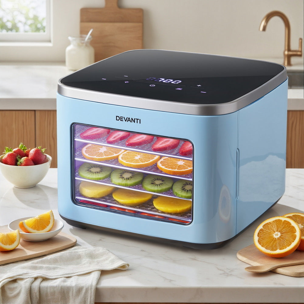 Blue food dehydrator with digital display dehydrating sliced fruits on kitchen counter